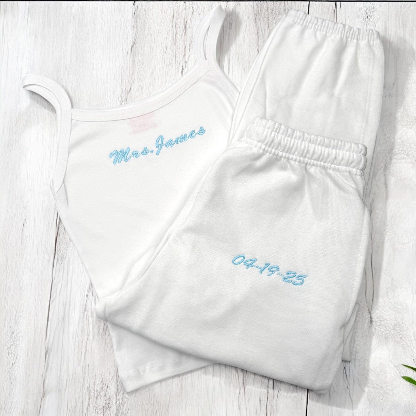 two white onesuits with blue writing on them