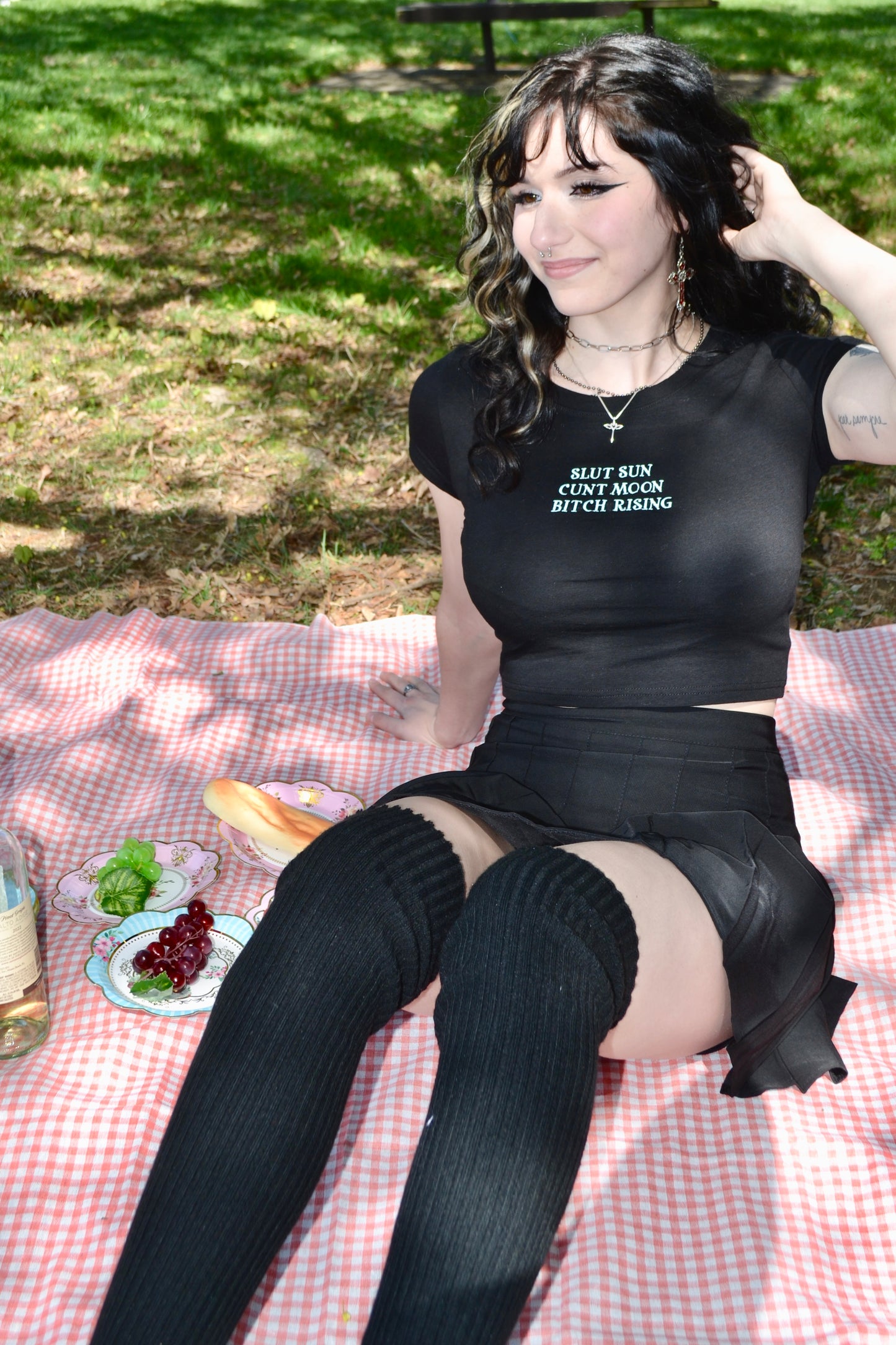 a woman sitting on top of a picnic blanket