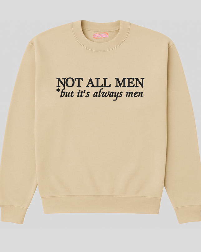 A beige sweatshirt with the text "NOT ALL MEN but it's always men" printed on it.