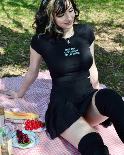 a woman sitting on a picnic blanket with a plate of food