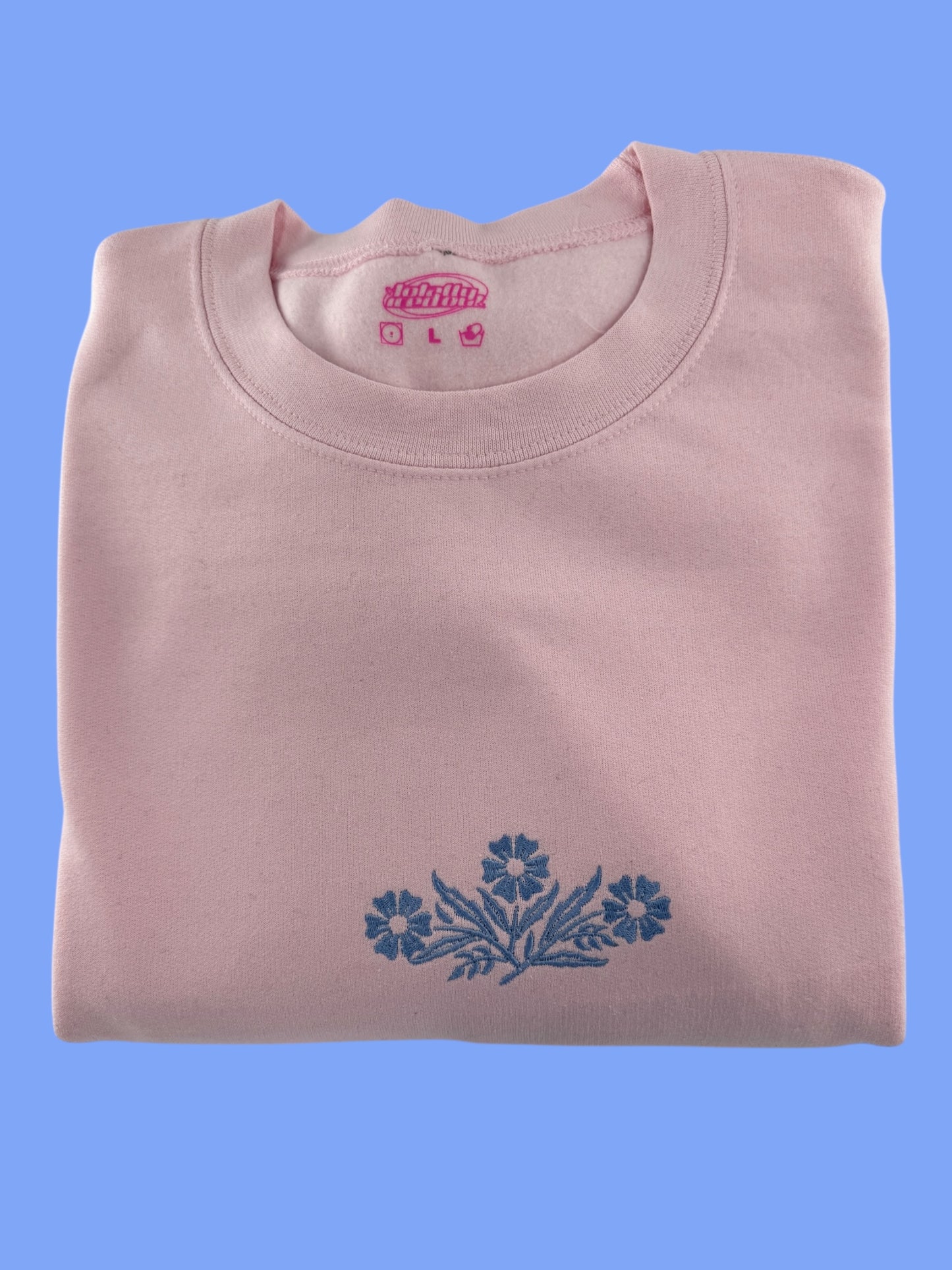 a pink shirt with blue flowers on it