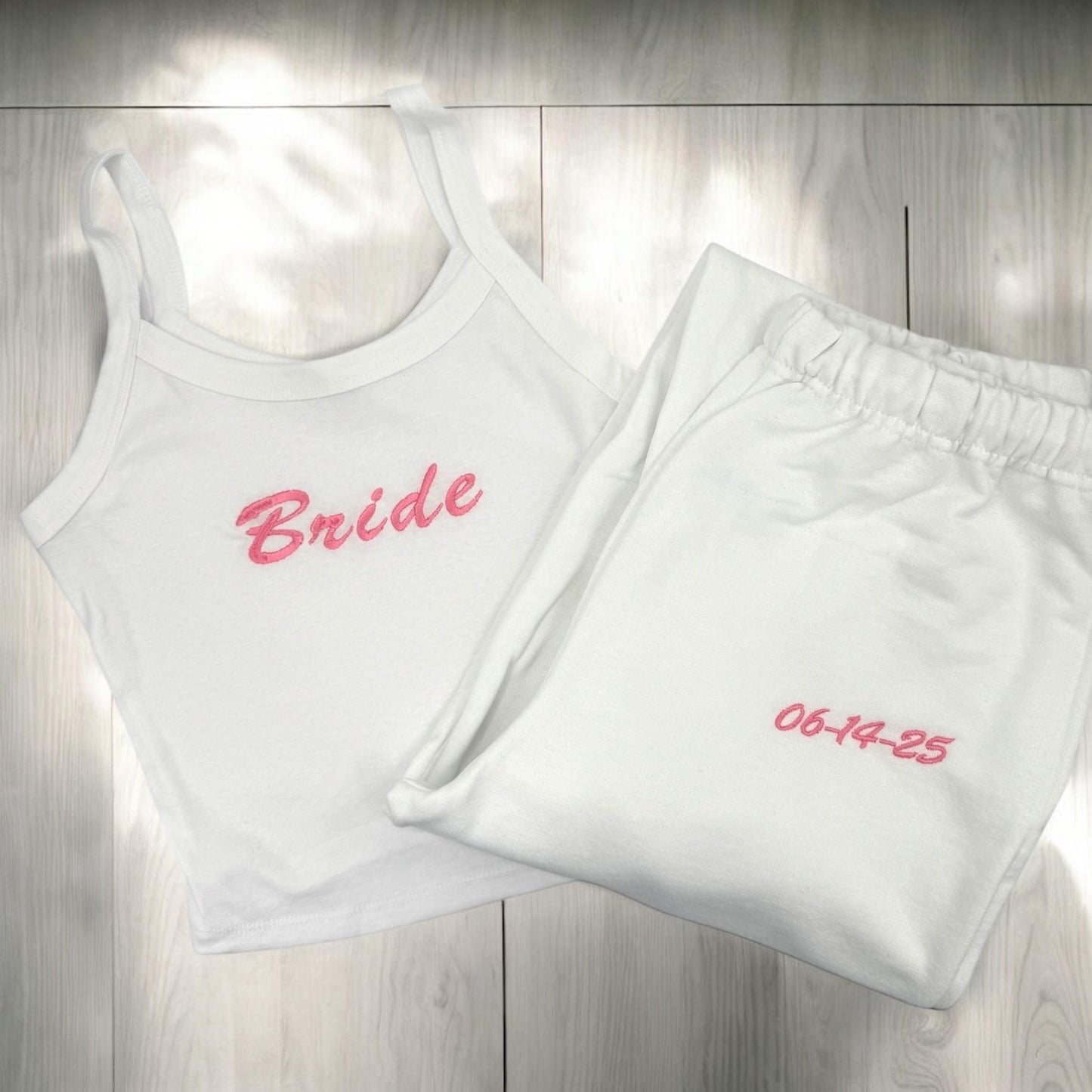 a white tank top with a pink bride embroidered on it