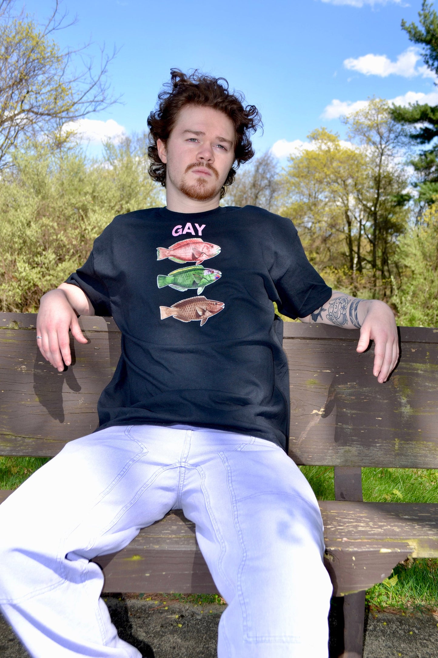 a man sitting on a wooden bench in a park
