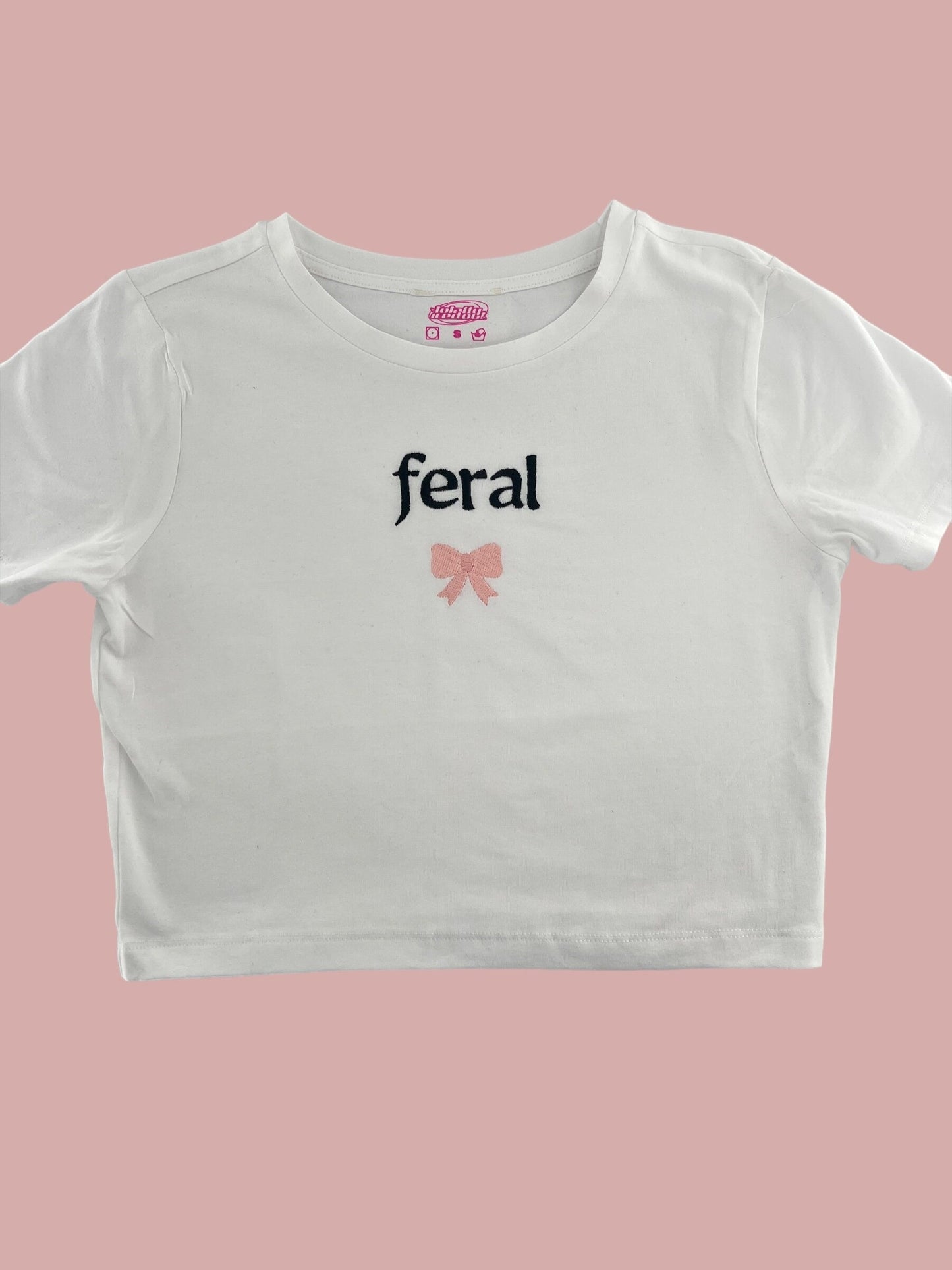 a white crop top with a pink bow on the chest