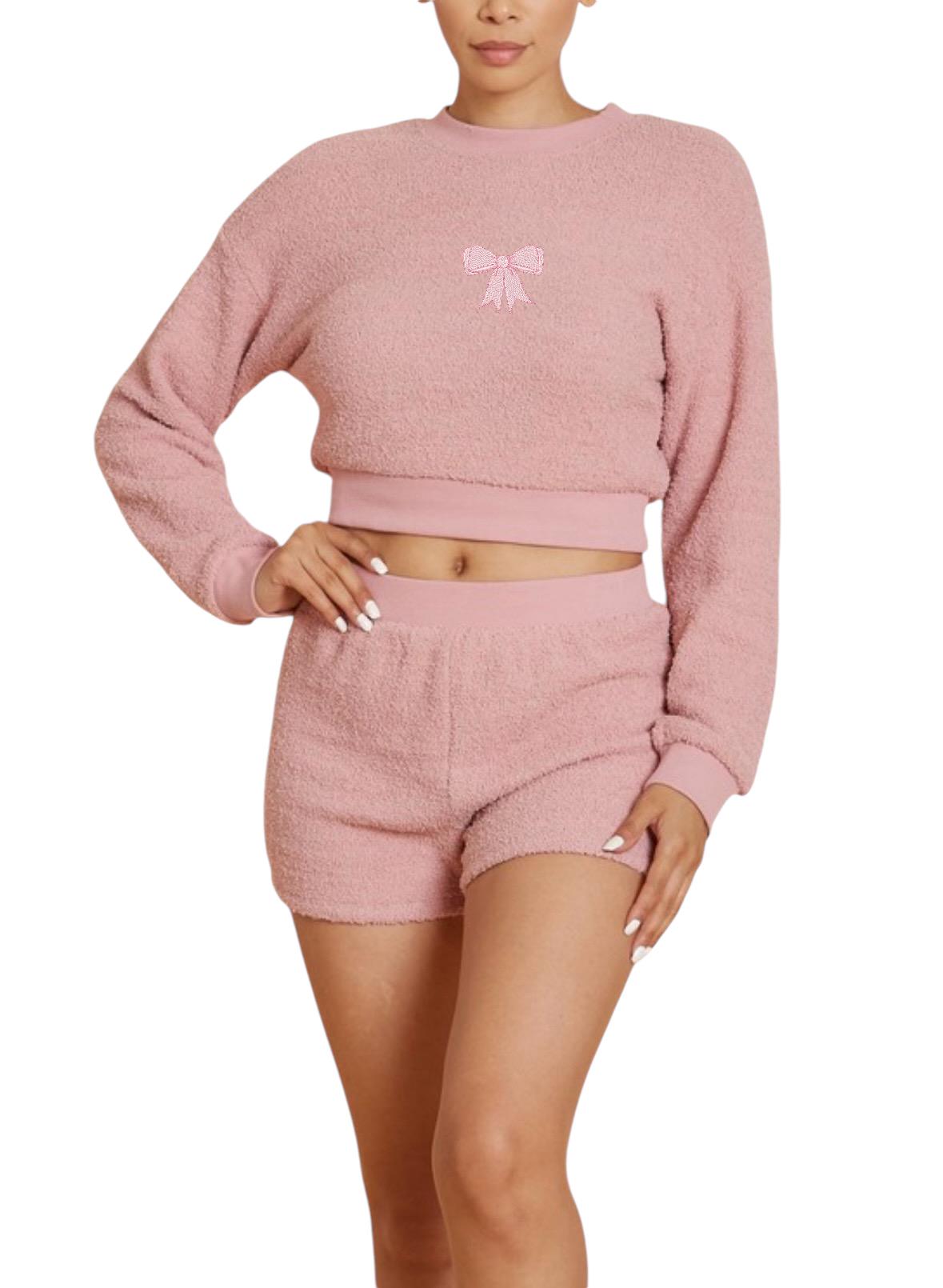 a woman wearing a pink sweater and shorts