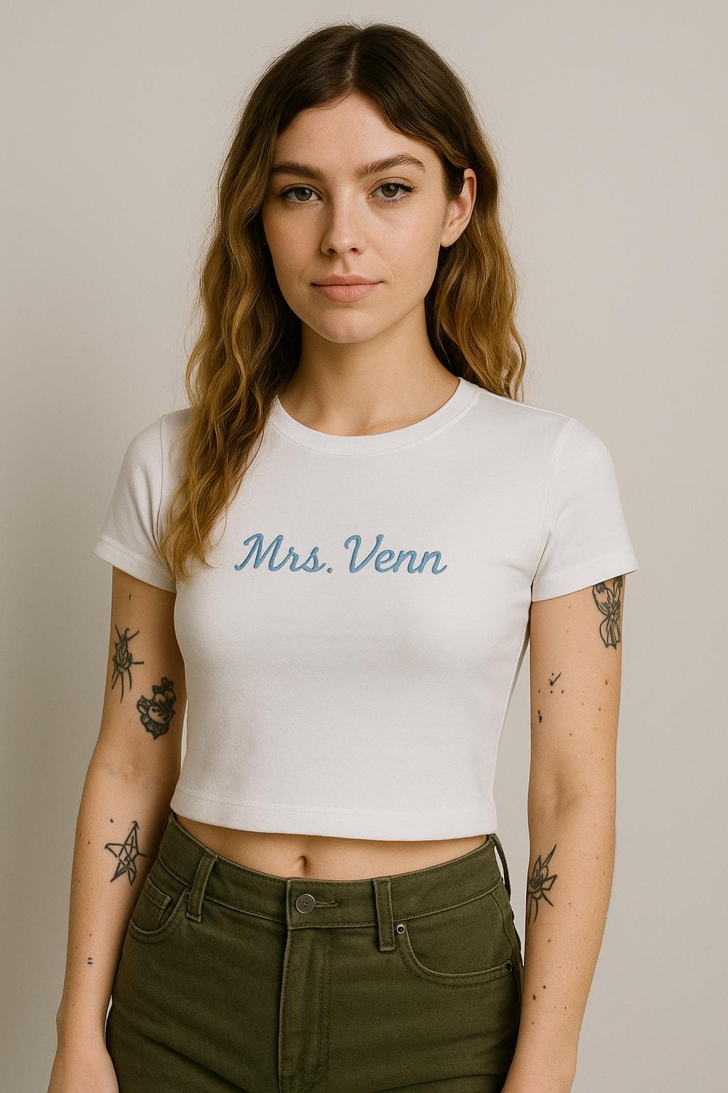 a woman with a tattoo on her arm wearing a white shirt