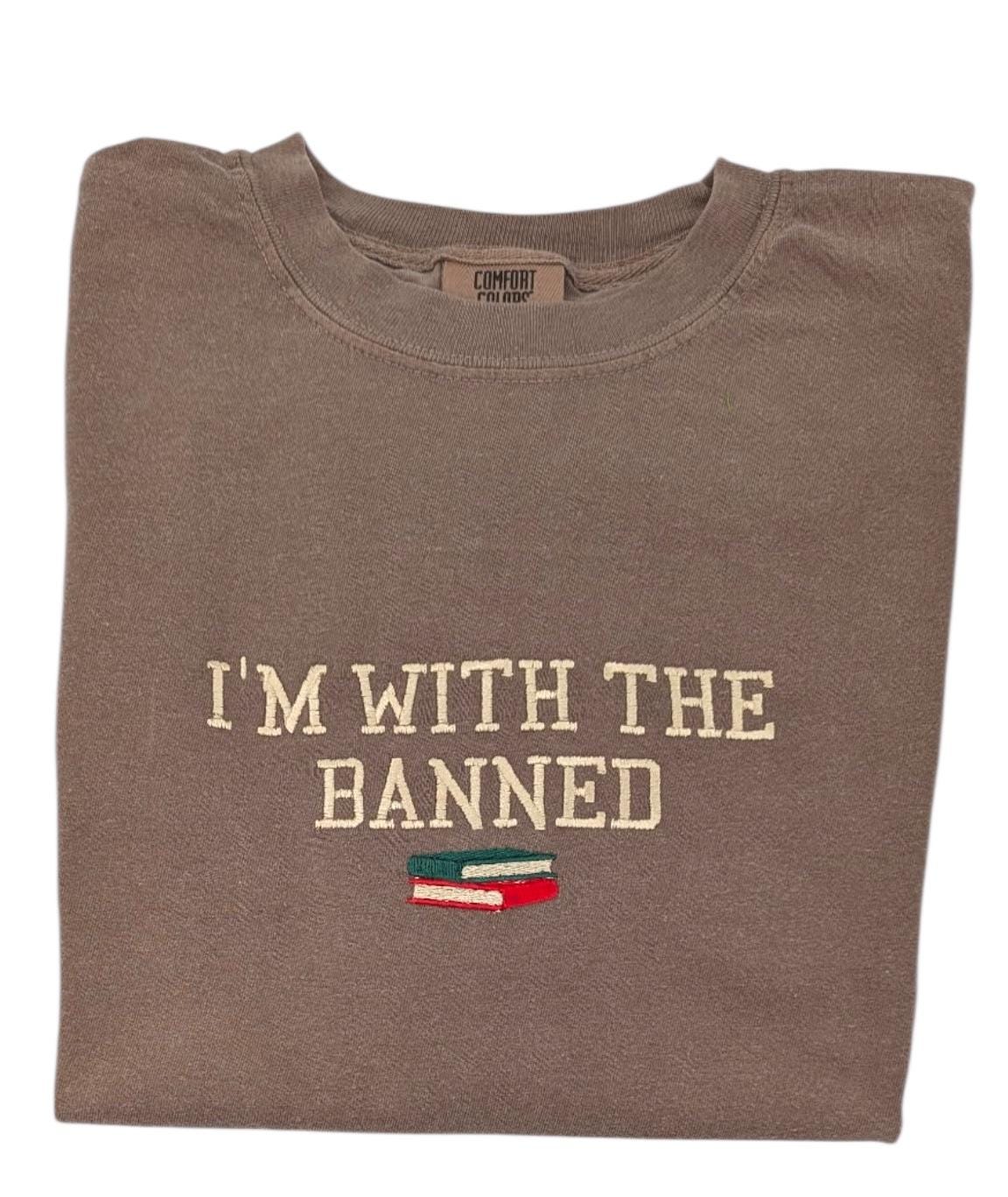 a brown t - shirt that says i'm with the banned