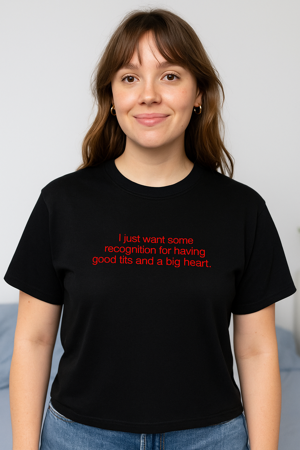 A woman wearing a black t-shirt with text on it, smiling at the camera.