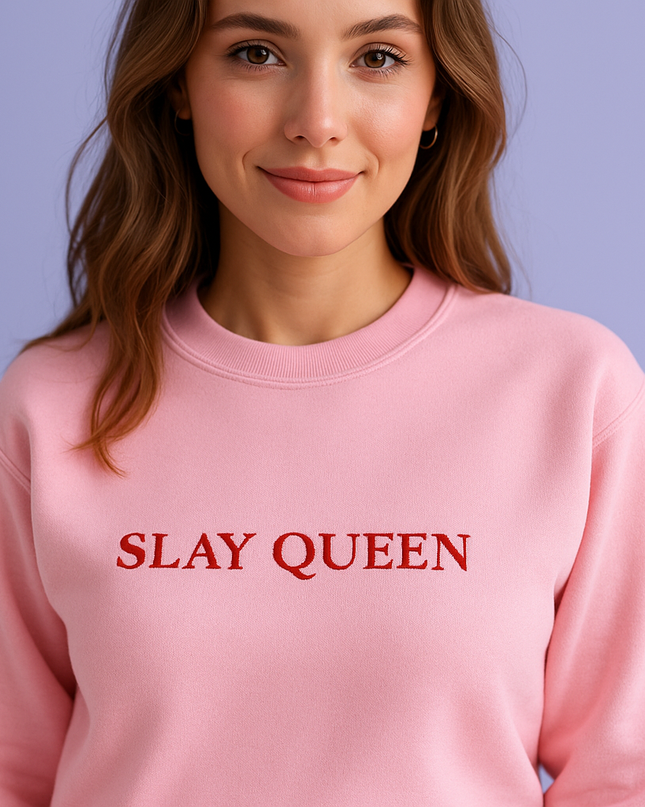 A woman wearing a pink sweatshirt with the text "SLAY QUEEN" printed on it.