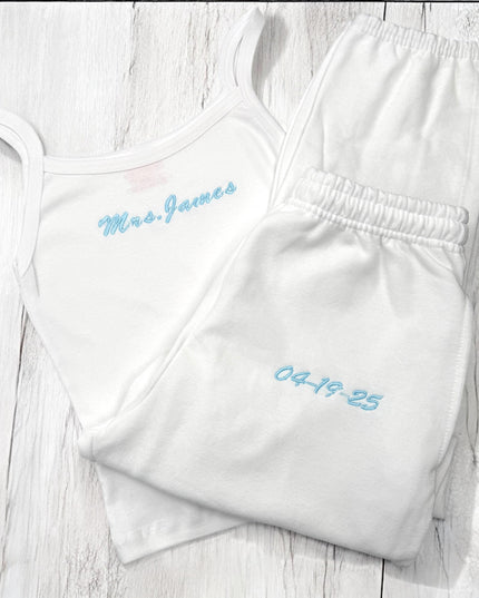 two white onesuits with blue writing on them