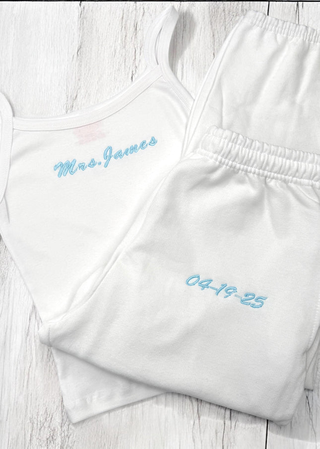 two white onesuits with blue writing on them
