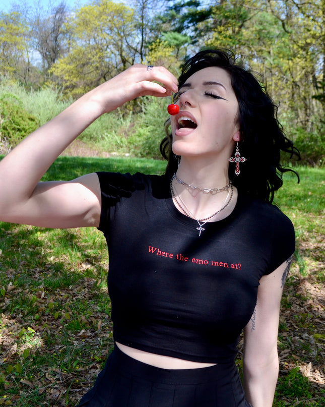 a woman in a black shirt is holding a red object