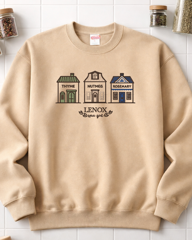 A beige sweatshirt with a graphic design depicting three houses labeled "Thyme", "Nutmeg", and "Rosemary" on a white background.