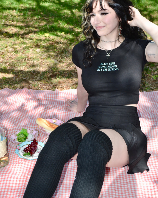 a woman sitting on top of a picnic blanket