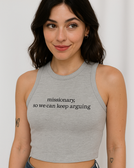 A young woman with dark hair and a gray tank top with the text "missionary, so we can keep arguing" is smiling at the camera.
