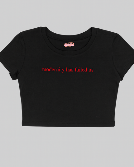 A black crop top with the text "modernity has failed us" printed on it.