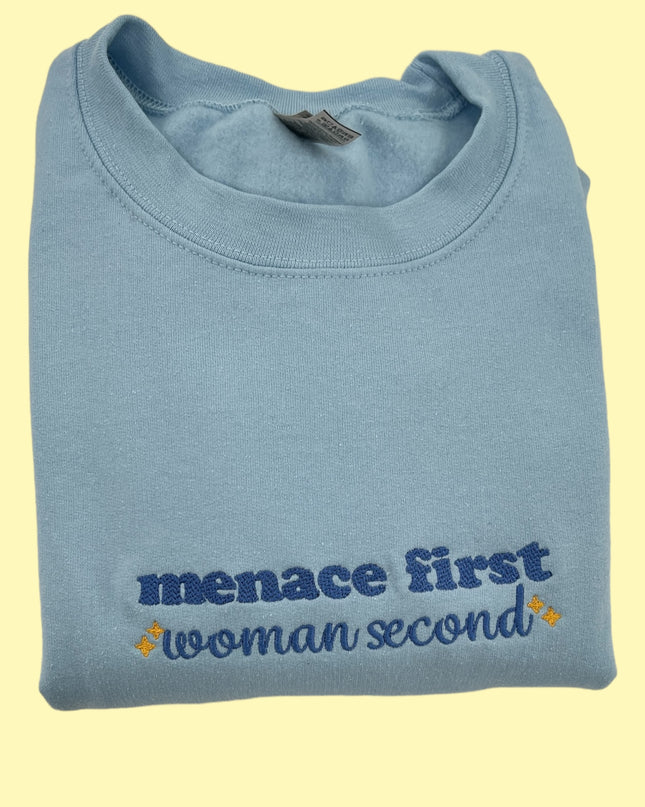 a blue t - shirt that says menace first woman second