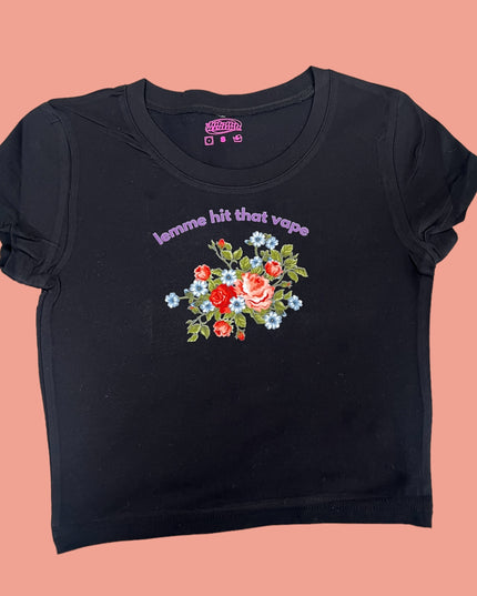 A black t-shirt with a floral design and text printed on it.