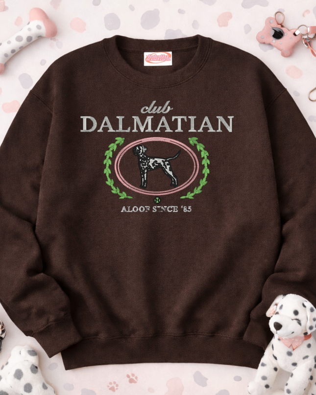 A brown sweatshirt with a graphic design featuring a Dalmatian dog and the text "club DALMATIAN" and "ALOOF STACE '85".