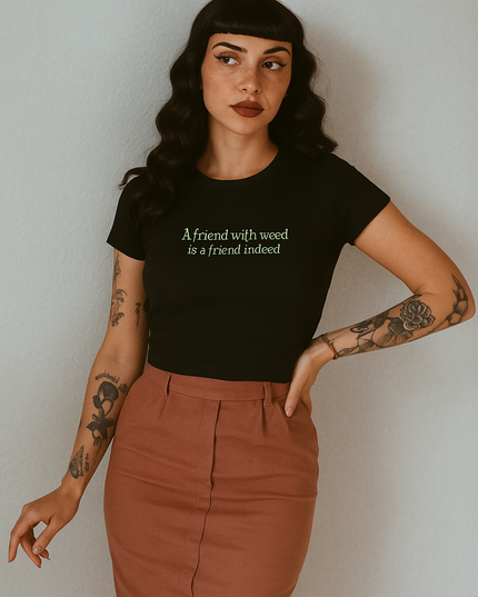 A woman with long dark hair wearing a black t-shirt with text and a brown skirt stands against a white background.