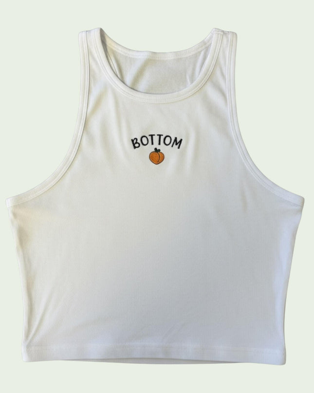 A white crop top with the word "BOTTOM" printed on it.