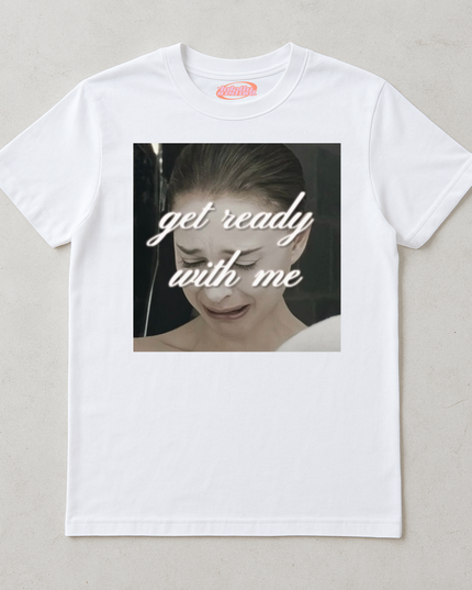 A white t-shirt with a graphic design featuring a close-up of a person's face with the text "get ready with me" overlaid on the image.
