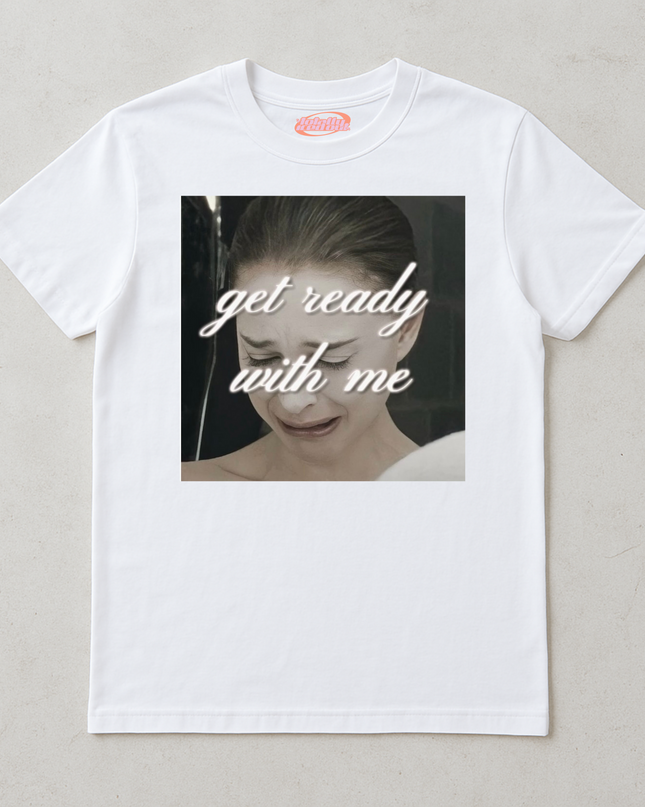 A white t-shirt with a graphic design featuring a close-up of a person's face with the text "get ready with me" overlaid on the image.
