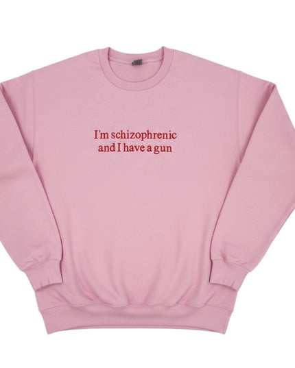 A pink sweatshirt with the text "I'm schizophrenic and I have a gun" printed on it.