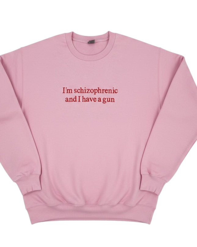 A pink sweatshirt with the text "I'm schizophrenic and I have a gun" printed on it.