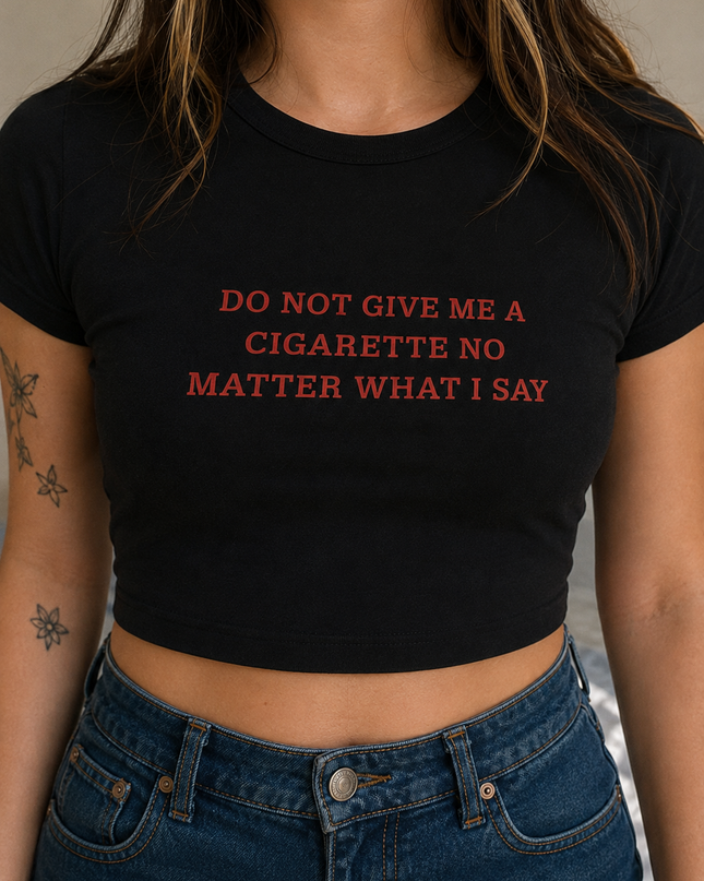 A person wearing a black crop top with the text "DO NOT GIVE ME A CIGARETTE NO MATTER WHAT I SAY" printed on it.