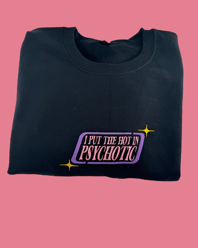A black sweatshirt with a purple and yellow graphic on the front, which says "I PUT THE HOT IN PSYCHOTIC" in a stylized font.