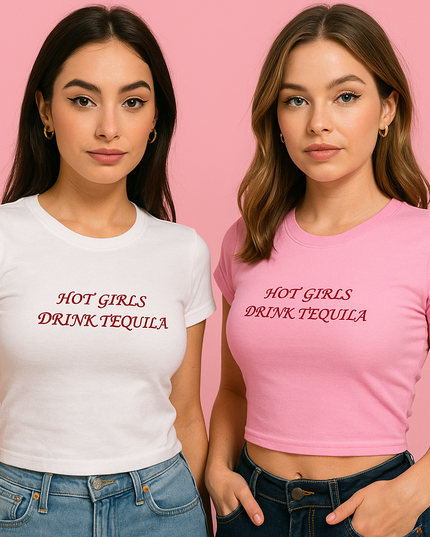 Two young women wearing white and pink t-shirts with the text "HOT GIRLS DRINK TEQUILA" printed on them, standing against a pink background.