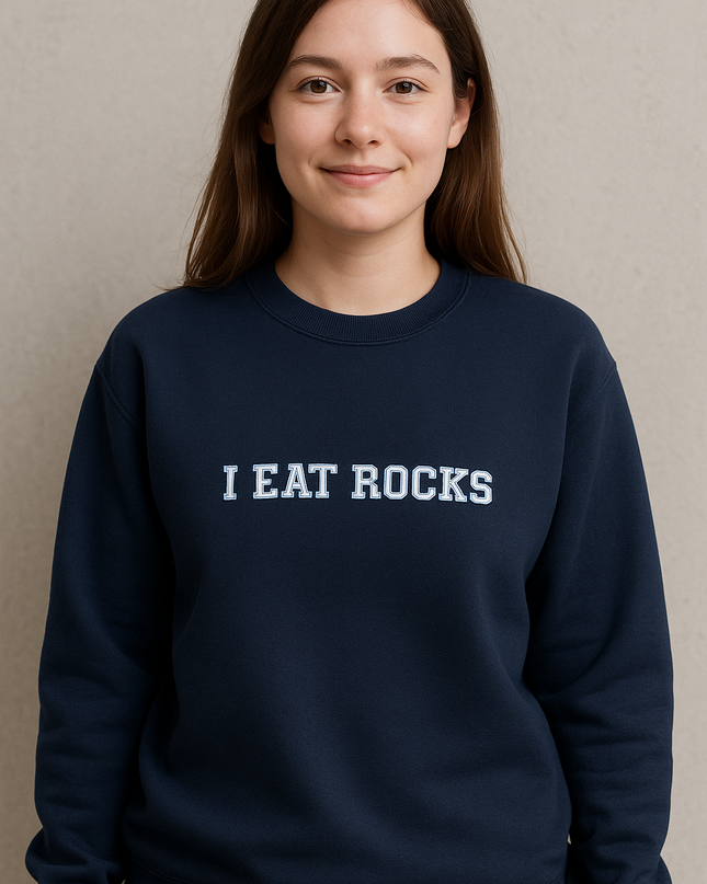 A young woman wearing a navy blue sweatshirt with the text "I EAT ROCKS" printed on it.