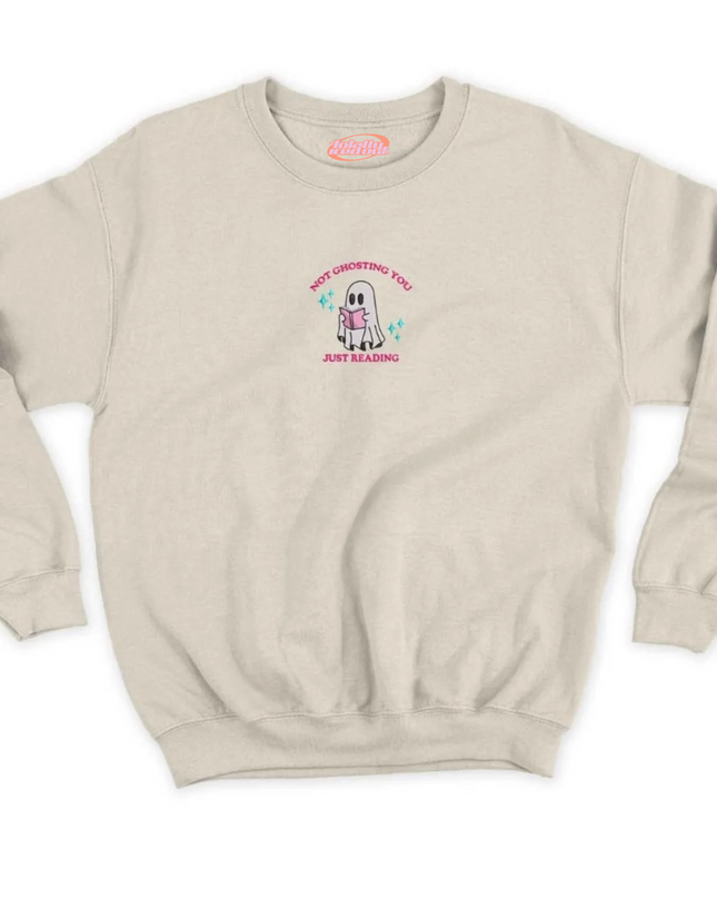 A beige sweatshirt with a graphic design on the front. The design features a cartoon character wearing a pink shirt and the text "NOT UNDERSTANDING YOU JUST KEEP DOING".
