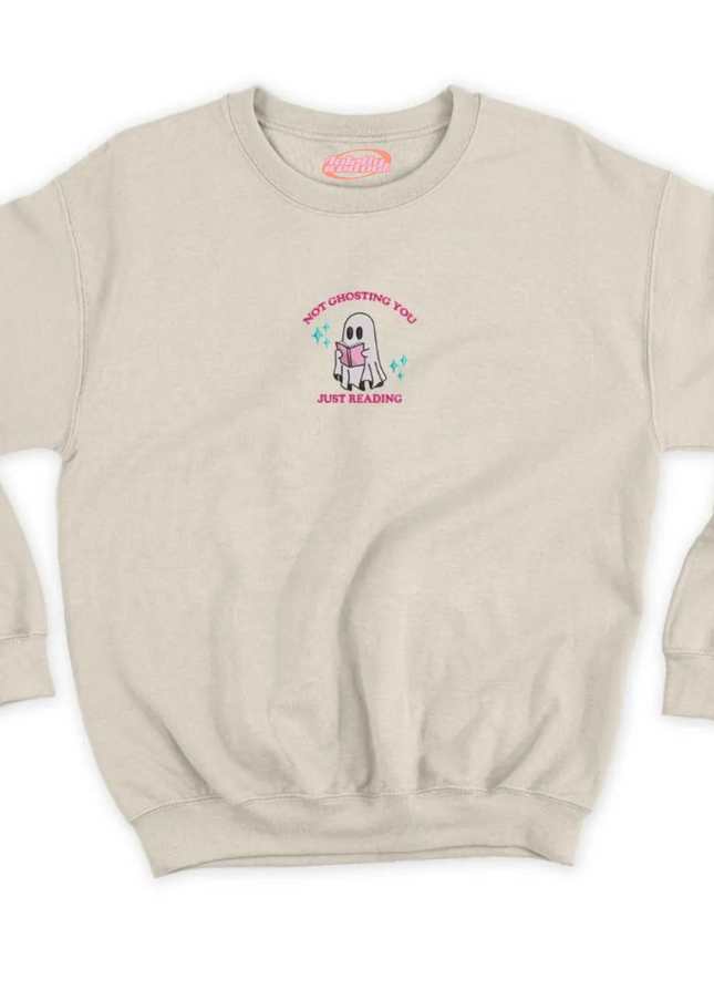 A beige sweatshirt with a graphic design on the front. The design features a cartoon character wearing a pink shirt and the text "NOT UNDERSTANDING YOU JUST KEEP DOING".