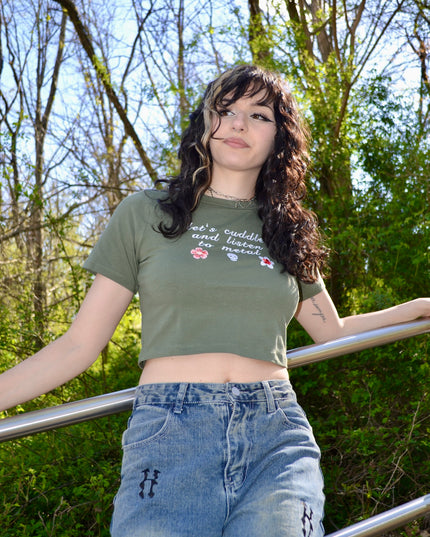 a woman in a green shirt leaning on a rail