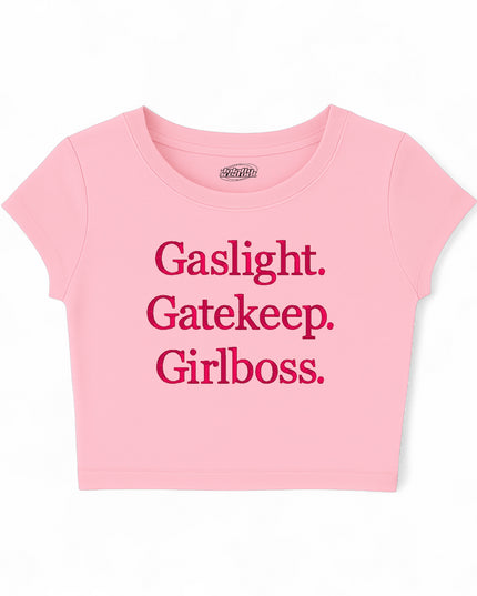 A pink cropped t-shirt with the text "Gassylight. Gatekeeper. Girl boss." printed on it.