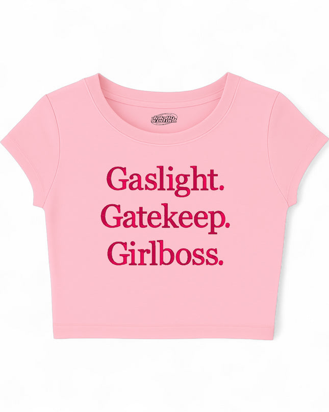 A pink cropped t-shirt with the text "Gassylight. Gatekeeper. Girl boss." printed on it.