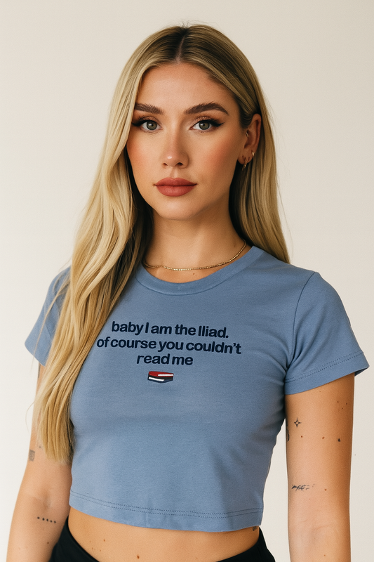 A young woman with long blonde hair wearing a blue crop top with text on it.