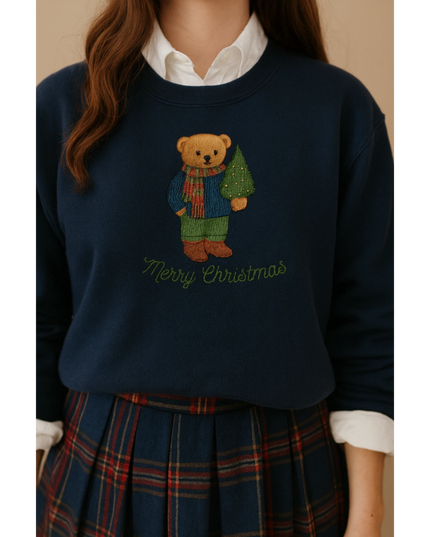 A woman wearing a navy blue sweater with a teddy bear design and the text "Merry Christmas" on it.