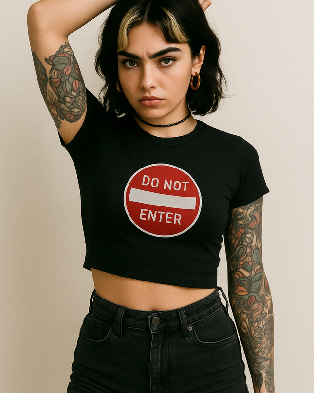 a woman with tattoos and a don't enter sign on her shirt