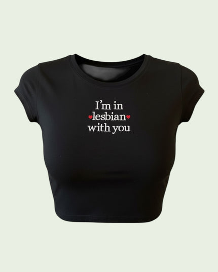A black crop top with white text that reads "I'm in Lesbian with you".