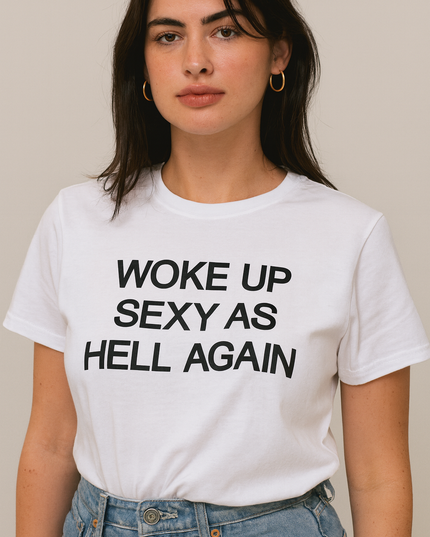 A woman wearing a white t-shirt with the text "Woke up sexy as hell again" printed on it.