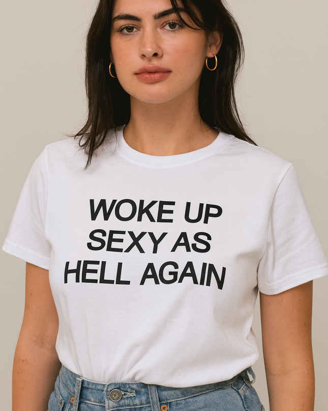 A woman wearing a white t-shirt with the text "Woke up sexy as hell again" printed on it.
