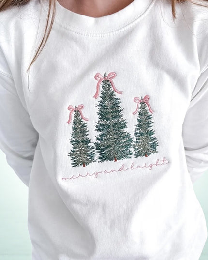 A white long-sleeved shirt with a Christmas tree design and the text "Merry and bright" printed on it.