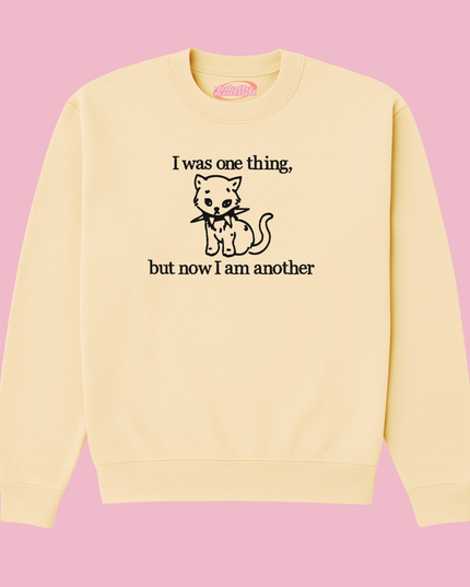 A yellow sweatshirt with a black cat graphic and text printed on it.