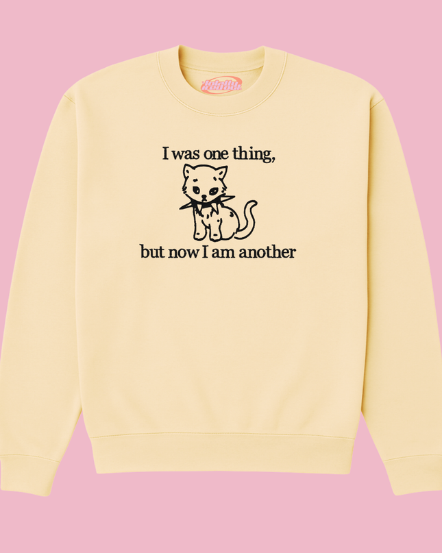 A yellow sweatshirt with a black cat graphic and text printed on it.