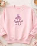 A pink sweatshirt with a graphic design of a stylized champagne glass and a ribbon on the front.