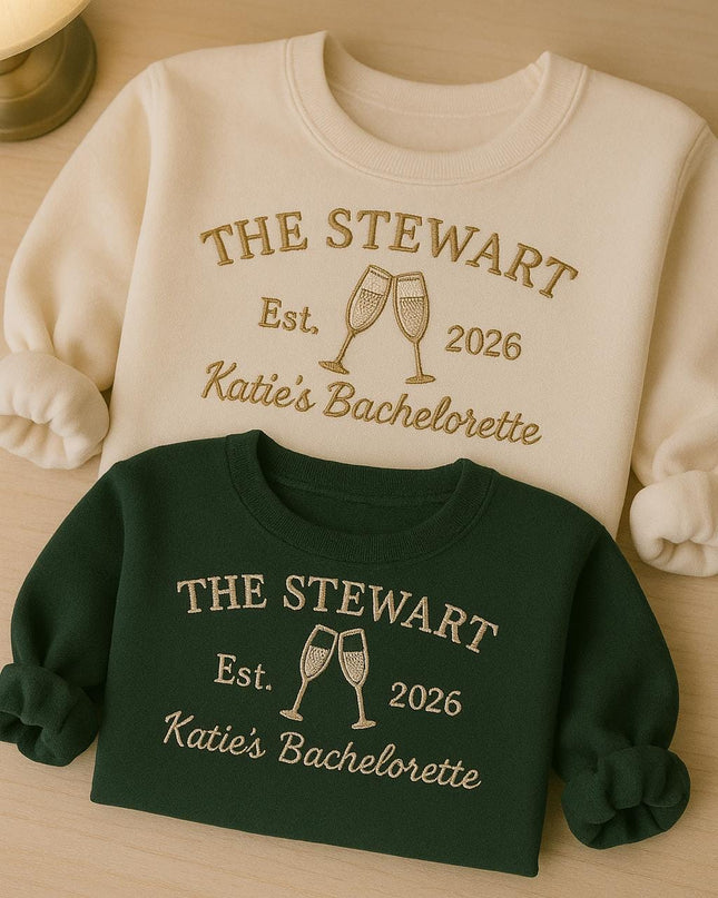two sweatshirts with the same design, one white and one green, both with the text "THE STEWART Est. 2026 Katie's Bachelorette" printed on them.