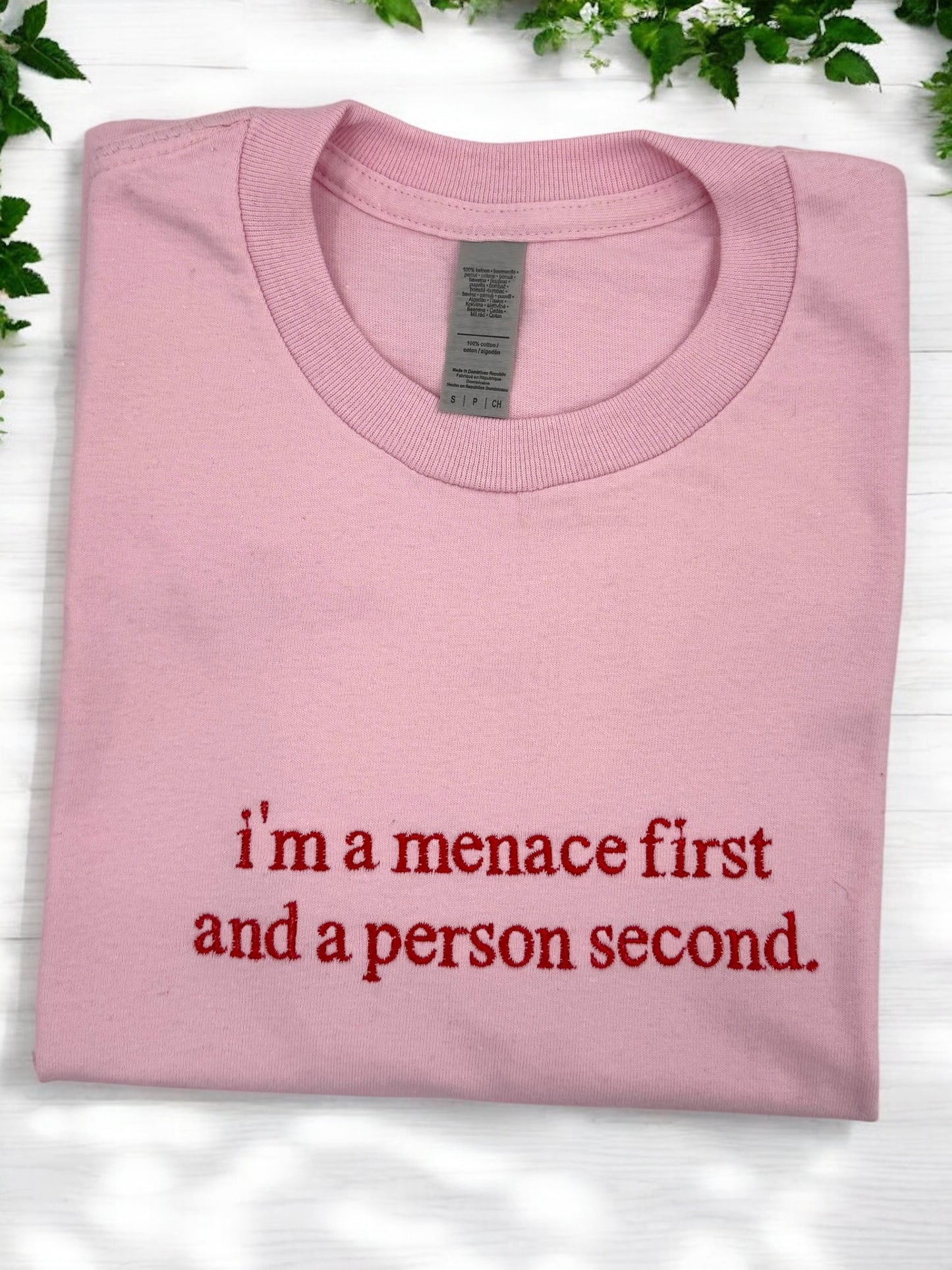 a pink shirt that says i'm a menace first and a person second